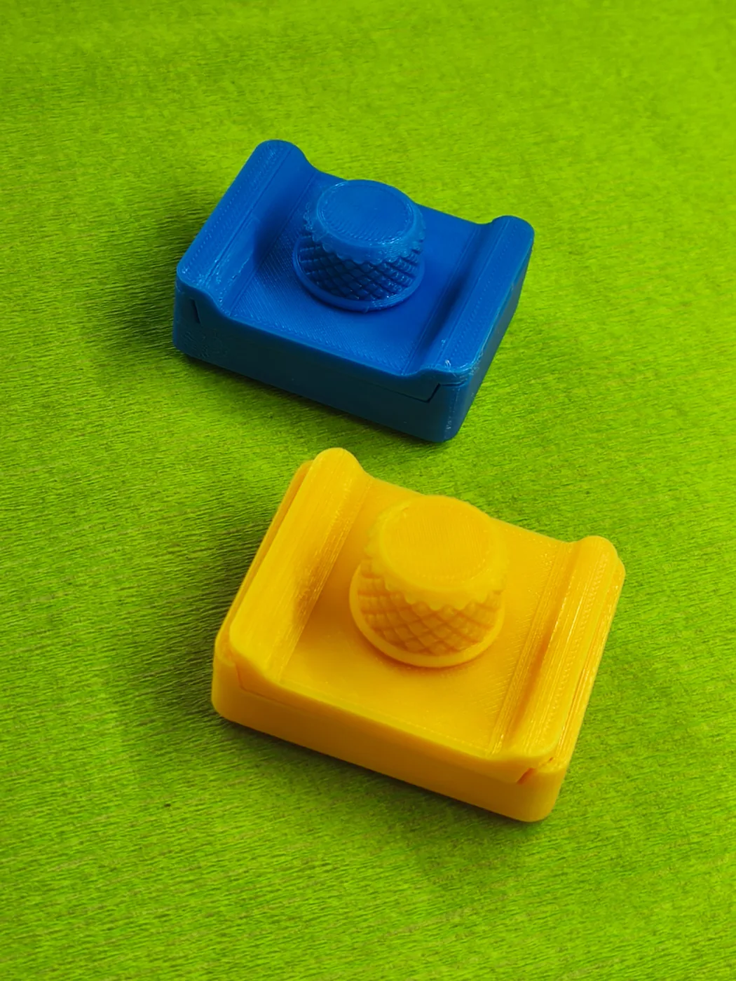 Deux tampons de nettoyage montés, un jaune et un bleu, avec leur microfibre grise